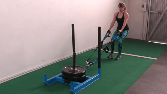 female performing sled pull