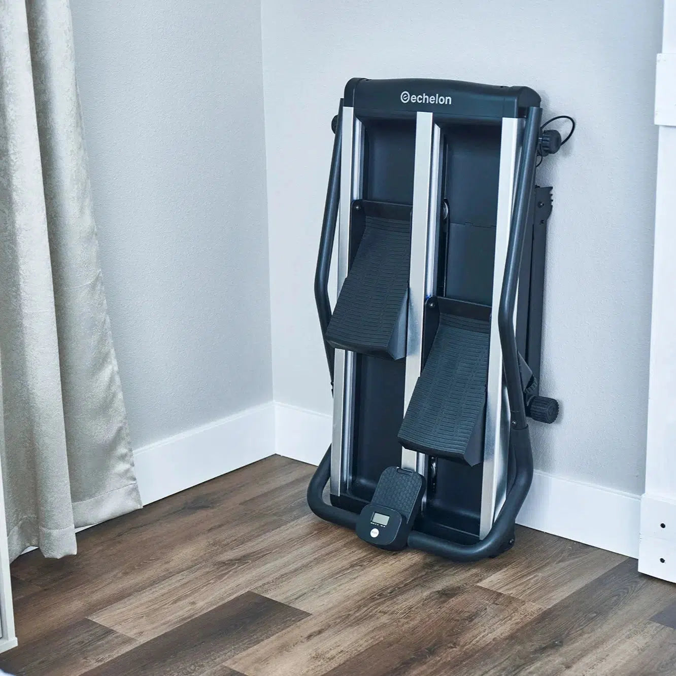 Lifestyle image of folded echelon stair climber leaning against the wall